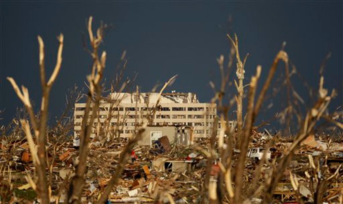 The damaged St. John's Regional Medical Center is seen in the distance through tornado debris in Joplin, Mo., Monday, May 23, 2011. A large tornado moved through much of the city Sunday, damaging the hospital and hundreds of homes and businesses and killing at least 89 people. (AP Photo/Charlie Riedel) (AP)