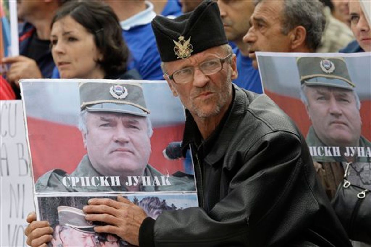 A Bosnian Serb man holds a photo of former Gen. Ratko Mladic during a protest in Kalinovik, Bosnia, hometown of the Bosnian Serb wartime military leader, 70 kms southeast of Sarajevo, Sunday, May 29, 2011. Approximately 3,000 Bosnian Serbs, gathered to show support and anger after the arrest of Mladic. Protestors carried banners and flags and sang songs in his support, he was arrested after 16 years in hiding from the International War Crimes Tribunal in the Hague. Mladic is to face trial on 15 accounts of war crimes including genocide in Srebrenica in 1995. (AP Photo/Amel Emric) (AP)