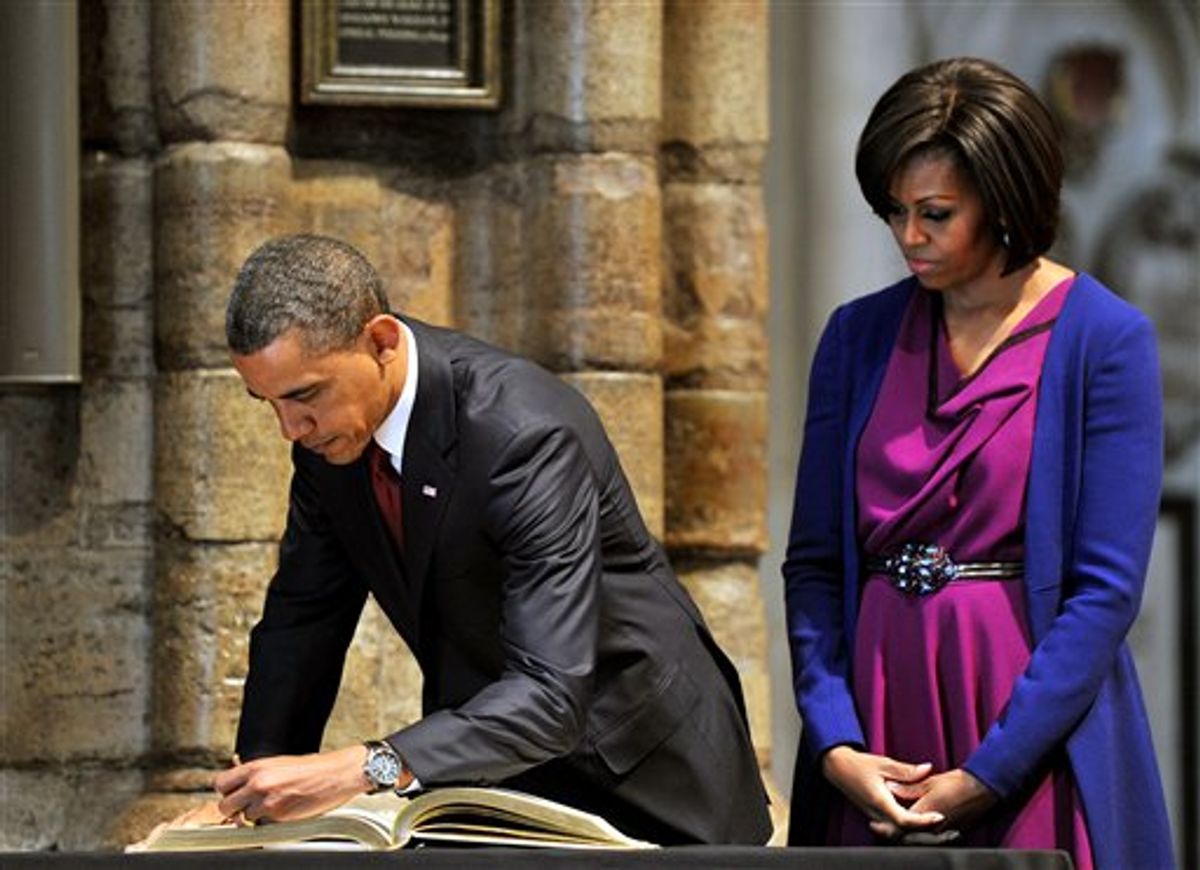 US President Barack Obama,  watched by his wife, first lady Michelle Obama, signs the distinguished visitors book during a tour of Westminster Abbey, in central London, Tuesday May 24, 2011. President Barack Obama and first lady Michelle Obama traded-in Irish charm for the pomp and pageantry of Buckingham Palace Tuesday as they opened a state visit to Britain at the invitation of Queen Elizabeth II. (AP Photo/John Stillwell/Pool) (AP)
