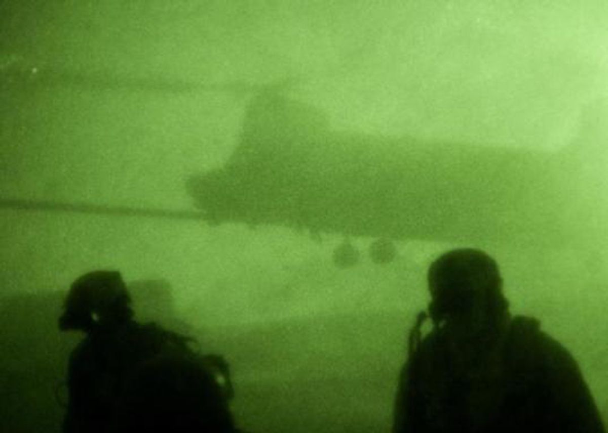 Navy SEALs in Afghanistan with an MH-47 Chinook in the background.