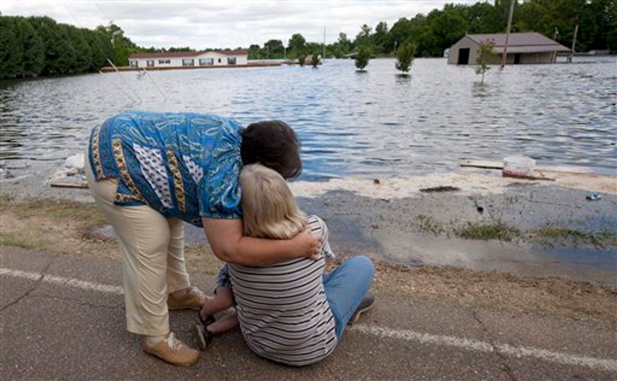Brenda Hynum, left,  hugs her daughter Debra Emery as she watches floodwaters rise around her mobile home in Vicksburg, Miss., Monday, May 16, 2011. A sand berm they built around their trailer failed in the night and floodwaters from the rising Mississippi river rushed in. "We tried so hard to stop it. It goes from anger to utter disbelief that this could happen. I just want to go home." Emery said. (AP Photo/Dave Martin)  (AP)