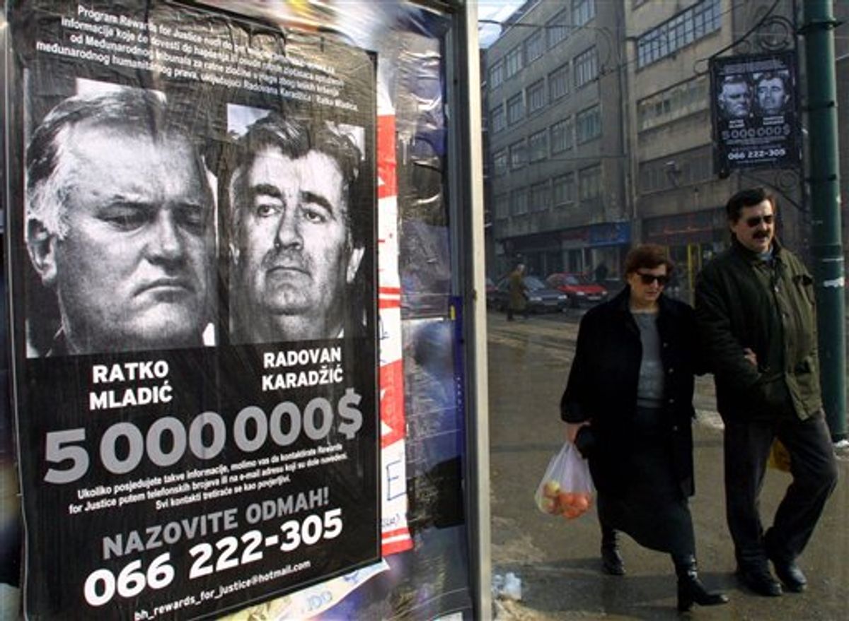 FILE In this Jan. 20, 2002 photo, a Bosnian couple passes by a poster of  Bosnia's two most wanted war crimes suspects, the leader of Bosnian Serbs Radovan Karadzic and his war time commander Gen. Ratko Mladic, in Sarajevo.  Mladic, Europe's most wanted war crimes fugitive, has been arrested in Serbia, the country's president said Thursday, May 26, 2011. Mladic has been on the run since 1995 when he was indicted by the U.N. war crimes tribunal in The Hague, Netherlands, for genocide in the slaughter of some 8,000 Bosnian Muslims in Srebrenica and other crimes committed by his troops during Bosnia's 1992-95 war.  (AP Photo/Sava Radovanovic) (AP)