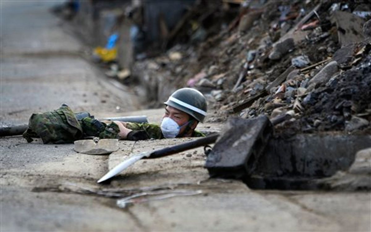 A Japan Ground Self-Defense Force soldier works in a sewer in an area devastated by the March 11 earthquake and tsunami in Taro, Iwate Prefecture, northeastern Japan, Friday, May 13, 2011. (AP Photo/Junji Kurokawa)  (AP)
