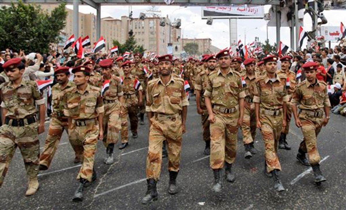 Yemeni army soldiers who joined the anti-government protestors , march during a ceremony to commemorate the anniversary of Yemen's reunification, in Sanaa, Yemen, Sunday, May 22, 2011. A deal for Yemeni leader Ali Abdullah Saleh to step down after 32 years in power was thrown into doubt Sunday after the ruling regime brought hundreds of loyalists into the streets to protest the pact and said he would not sign unless a public ceremony were held that included opposition leaders. (AP Photo/Hani Mohammed) (AP)