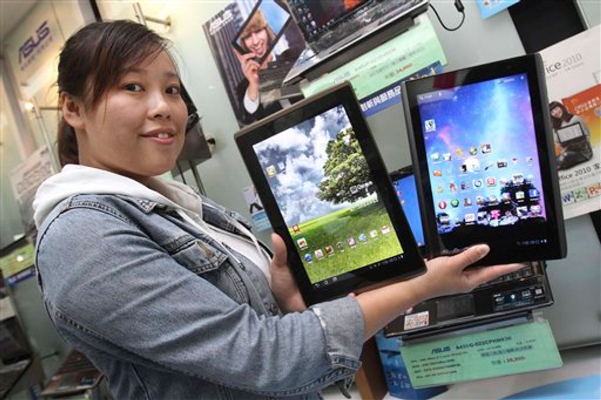 A showroom employee displays tablet computers from Taiwan's top two PC vendors, Acer Inc. and AsusTek Computer Inc. in Taipei, Taiwan, Saturday, May 28, 2011. Dozens of global computer firms and their obsession to get a piece of the expanding tablet computing market will be on full display Tuesday  May 31, 2011, as Computex, the world's second largest computer show, begins its annual five-day run in Taipei. (AP Photo/Chiang Ying-ying) (AP)