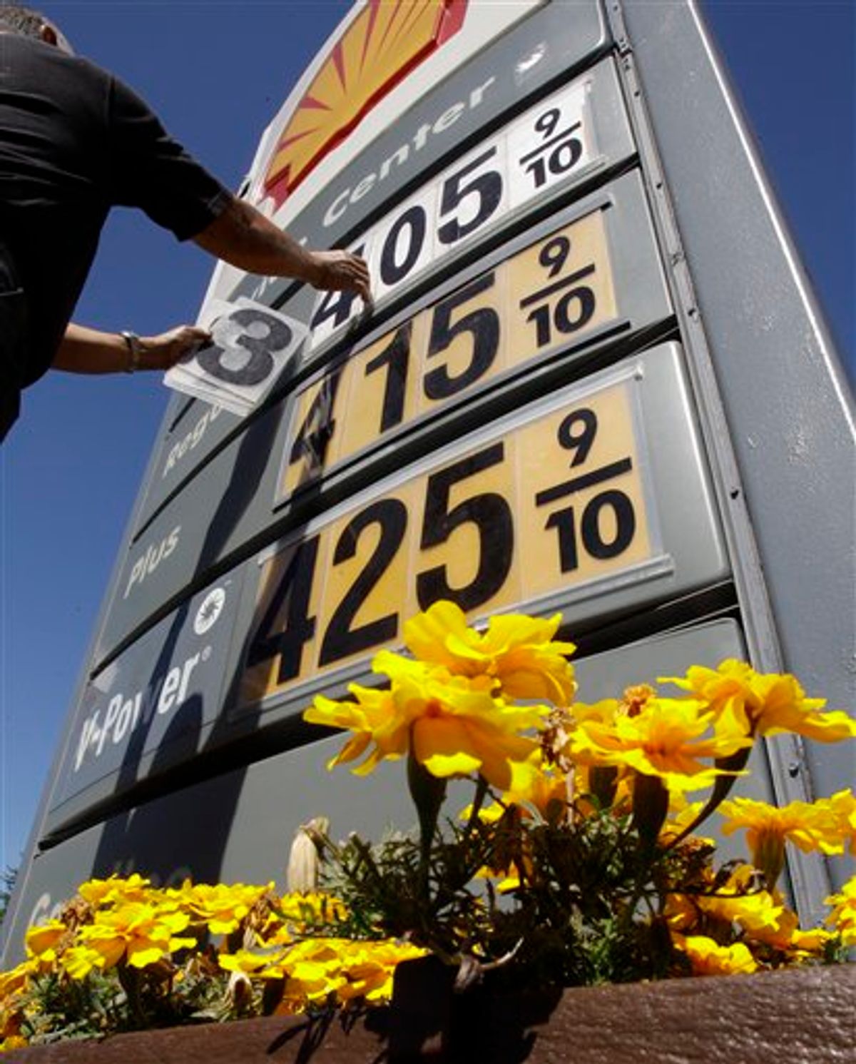 In this June 21, 2011, photo, Shell gas worker Toke Fusi lowers gas prices at a Shell gas station in Menlo Park, Calif. (AP Photo/Paul Sakuma)