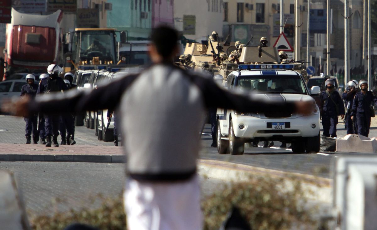 A resident spreads his arms in front of riot police and tanks moving into the Shiite Muslim village of Malkiya, Bahrain, southwest of Manama, on Sunday, March 20, 2011.Bahraini authorities are trying to crush a revolt by the nation's majority Shiites for greater political freedoms. Saudi Arabia and other Gulf states have sent forces to help Bahrain's Sunni dynasty. (AP Photo/Hasan Jamali) (Associated Press)