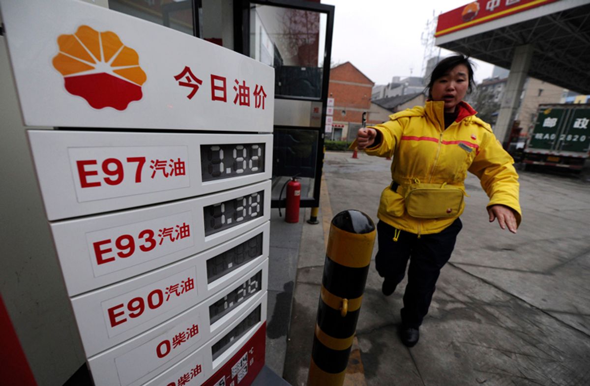 An employee gestures to stop a photographer from taking pictures near a board showing recently increased fuel prices at a gas station in Hefei, Anhui province April 7, 2011. China will increase retail gasoline and diesel prices by 5-5.5 percent to new record highs from Thursday, the government said, easing the burden of state refiners who face international oil prices at 2.5-year highs. REUTERS/Stringer (CHINA - Tags: BUSINESS ENERGY)  (Â© Jianan Yu / Reuters)