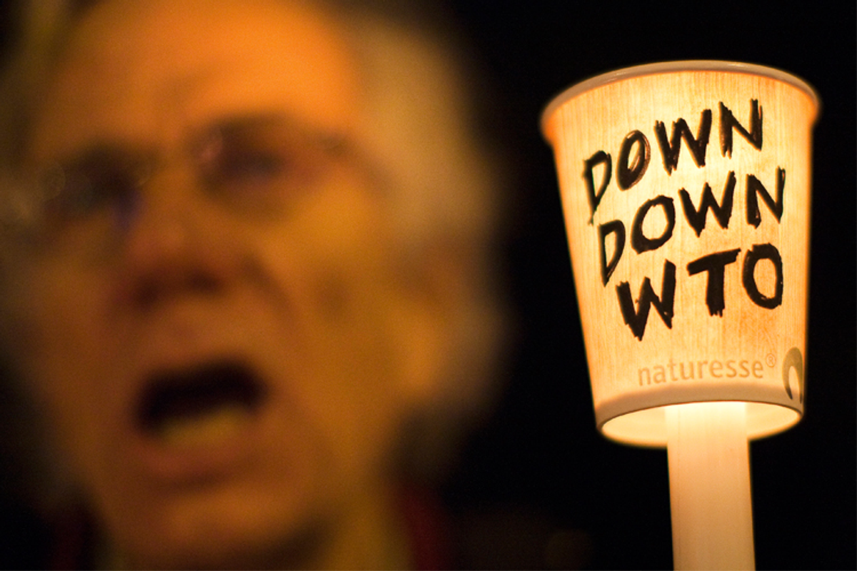 A protestor holds a candle during a demonstration against the WTO in Geneva on November 30, 2009