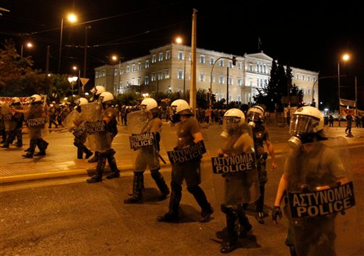 Riot police clear the street of protesters after clashes outside the Greek Parliament in Athens, early Wednesday, June 22, 2011. The Greek prime minister survived a crucial confidence vote early Wednesday, keeping alive a government dedicated to averting a debt default that could spark a financial maelstrom around the world. (AP Photo/Thanassis Stavrakis) (AP)