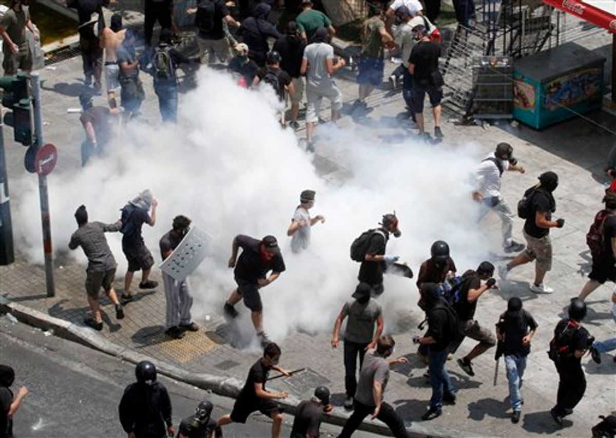 Demonstrators run away from tear gas  during a demo in Athens on Tuesday June 28, 2011. Greece's beleaguered government is bracing for a 48-hour general strike as lawmakers debate a new round of austerity reforms designed to win the country additional rescue loans needed avoid bankruptcy.(AP Photo/Dimitri Messinis)  (AP)
