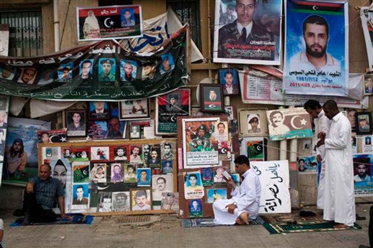 Men pray next to portraits of people killed or who disappeared during the rule of Libyan leader Moammar Gadhafi's regime during Friday prayers in Benghazi, Libya, June 3, 2011.  (AP Photo/Rodrigo Abd) (AP)
