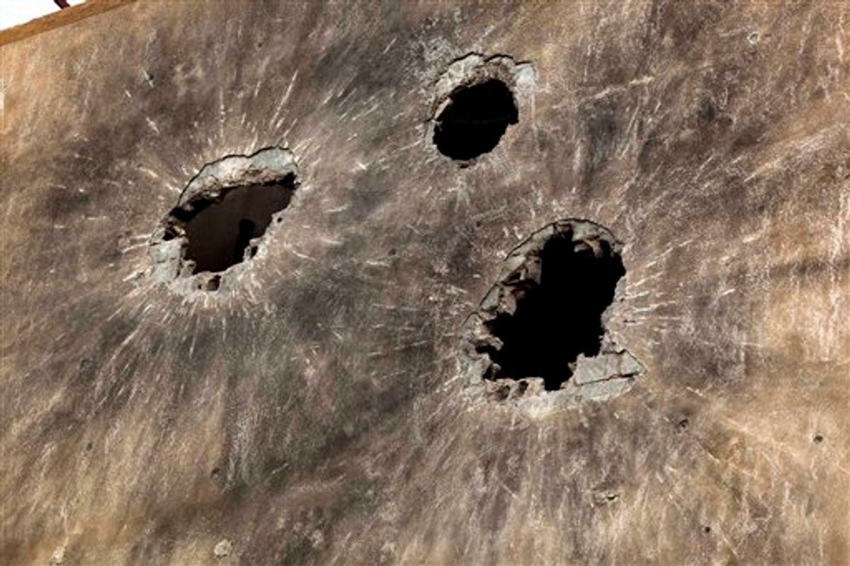 In this photo taken Sunday, May 22, 2011, holes caused by heavy ammunition are seen on the side wall of a building in Tripoli Street, the center of the fighting between forces loyal to Libyan-leader Moammar Gadhafi and rebels in downtown Misrata, Libya. Since the weeks-long siege of the city ended in mid-May, Misrata residents make pilgrimages to Tripoli Street, site of the fiercest fighting in the battle for Libya between the rebels and Moammar Gadhafi's forces. People gawk at the wreckage of bombed-out buildings with gaping holes and walls pocked by bullets, and shoot photos of charred hulks of tanks, rubble-strewn streets and a side walk museum featuring drumloads of bullet casings, uniforms of dead enemies, and unexploded munitions. (AP Photo/Rodrigo Abd) (AP)