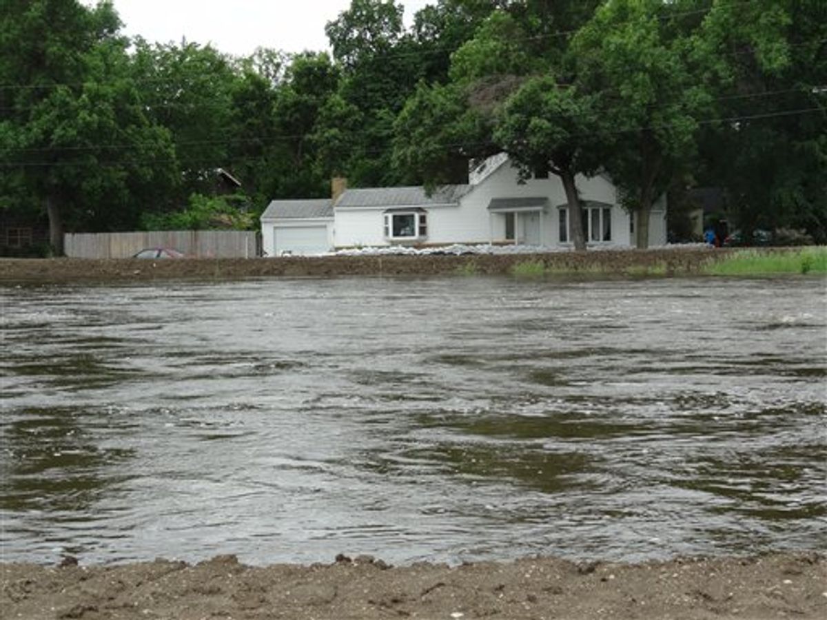 The Souris River passes near a home Tuesday, June 21, 2011, in Minot, N.D. About 11,000 Minot residents are being ordered to leave their homes even earlier than expected this week as the river gets closer to swamping the North Dakota city with the worst flooding in four decades, officials said Tuesday. (AP Photo/ The Forum, Teri Finneman) (AP)