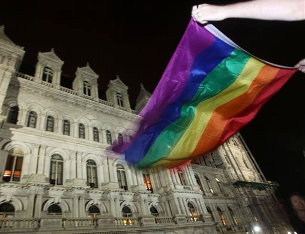 Robert Moore of New York waves a Pride flag outside the Capitol in Albany, N.Y., after the state Senate passed a bill legalizing same-sex marriage, on Friday, June 24, 2011.  (AP Photo/Mike Groll) (AP)