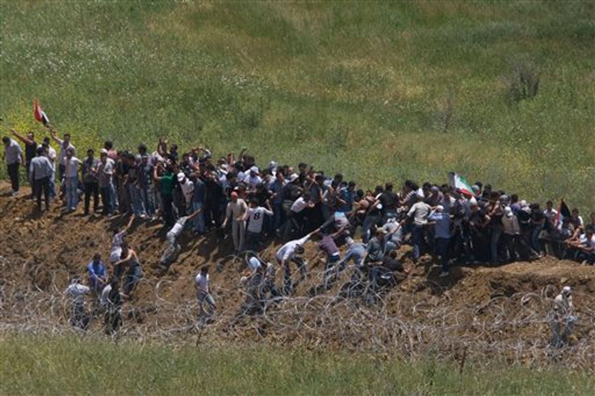 Pro Palestinians protesters try to break a fence along the border between Israel and Syria near the village of Majdal Shams in the Golan Heights, Sunday, June 5, 2011 . Israeli troops opened fire across the Syrian frontier on Sunday to disperse hundreds of pro-Palestinian protesters who stormed the border of the Israeli-controlled Golan Heights, reportedly killing four people in unrest marking the anniversary of the Arab defeat in the 1967 Mideast war. (AP Photo/Ariel Schalit) (AP)