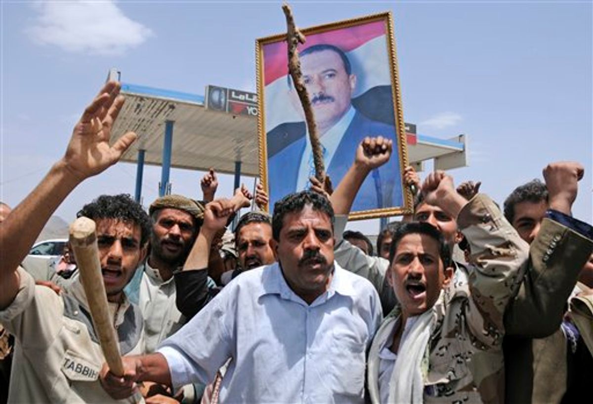 Supporters of Yemeni President Ali Abdullah Saleh hold up his portrait and chant slogans as they celebrate news that Saleh's health is stable, after being taken to Saudi Arabia to receive medical treatment for wounds he suffered in a rocket attack on his compound, in Sanaa, Yemen, Thursday, June 9, 2011. Government troops trying to recapture areas held by Islamic militants have killed 12 suspected al-Qaida members in the troubled southern province of Abyan, the Defense Ministry said Thursday. (AP Photo/Mohammed Al-Sayaghi) (AP)