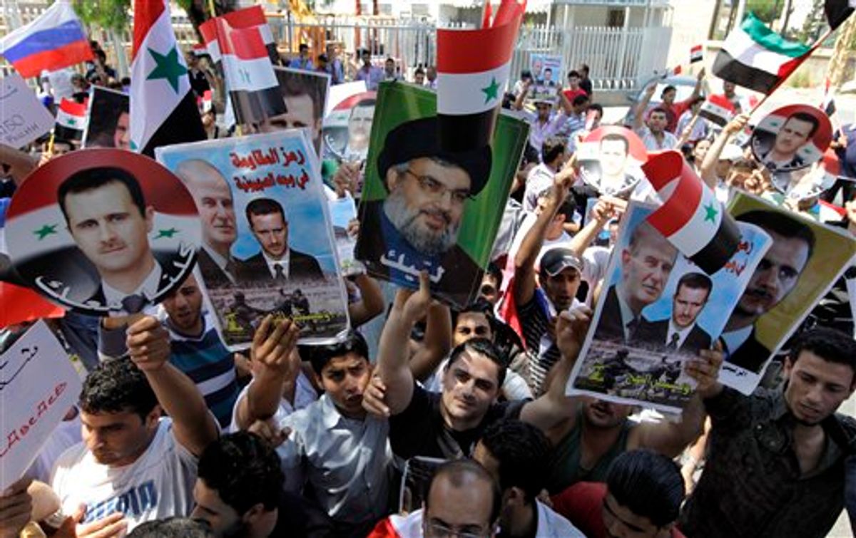 Protesters shout slogans as they carry pictures of Syrian President Bashar Assad, left, his father Hafez Assad, second from left, Hezbollah leader Sheik Hassan Nasrallah, center, and Syrian flags, during a demonstration to show their support for the Syrian President in front of the Russian Embassy, in Beirut, Lebanon, Sunday, June 19, 2011. (AP Photo/Bilal Hussein) (AP)