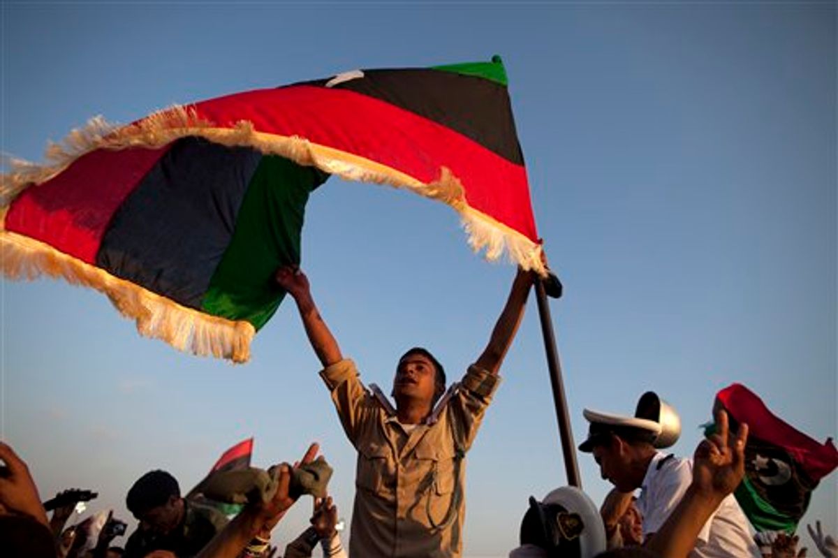 A new cadet for the Libyan rebel army holds a pre Moammar Gadhafi flag after a graduation ceremony for new cadets in Benghazi, Libya, Sunday, May 29, 2011.  (AP Photo/Rodrigo Abd) (AP)