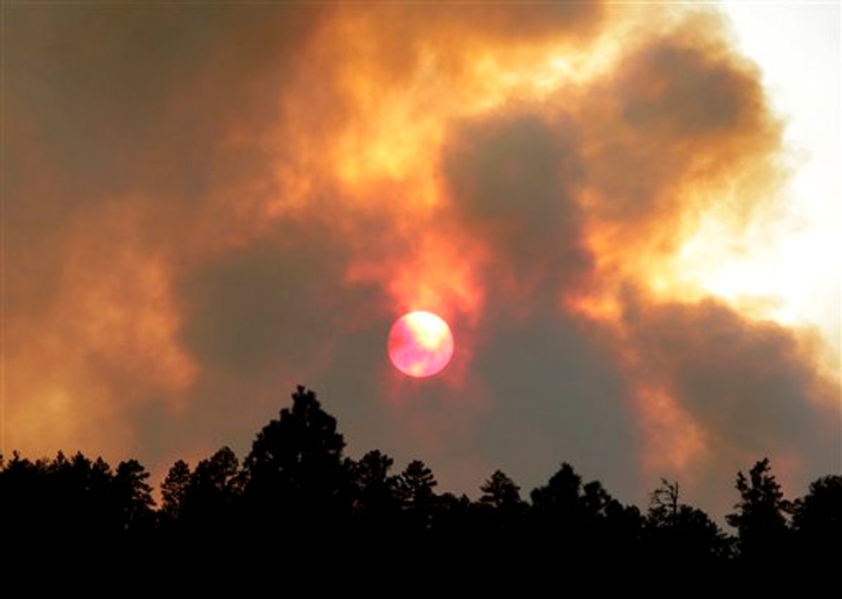 The sun sets behind smoke from the Wallow fire Tuesday, June 14, 2011 in Luna, N.M. The focus of the battle against the massive wildfire burning in eastern Arizona was on New Mexico as crews continued to light fires around the town of Luna to stop the flames. (AP Photo/Matt York)  (AP)