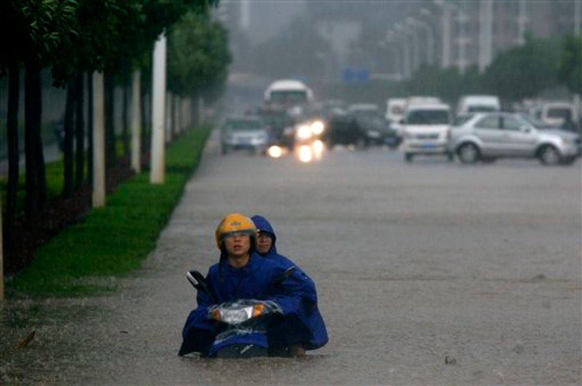Two men on a motorcycle are stuck in floodwaters in Wuhan in central China's Hubei province Saturday June 18, 2011. Flooding from this month's seasonal rains has already forced hundreds of thousands of people from their homes and left more than 170 dead or missing. (AP Photo) CHINA OUT (AP)