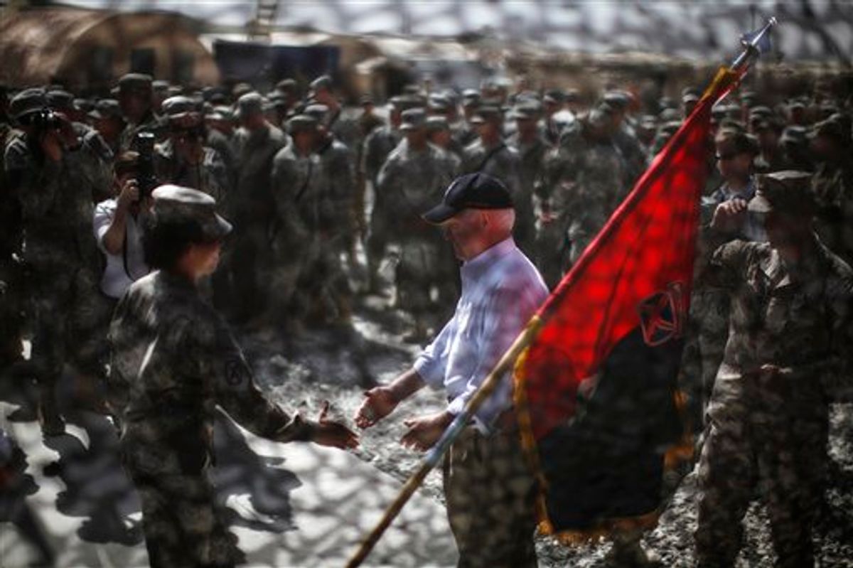 Defense Secretary Robert Gates is seen through camouflage netting as he greets US. Army soldiers at Forward Operating Base (FOB) Shank in Logar Province, Afghanistan, Monday, June 6, 2011.    (AP Photo/Jason Reed, Pool) (AP)