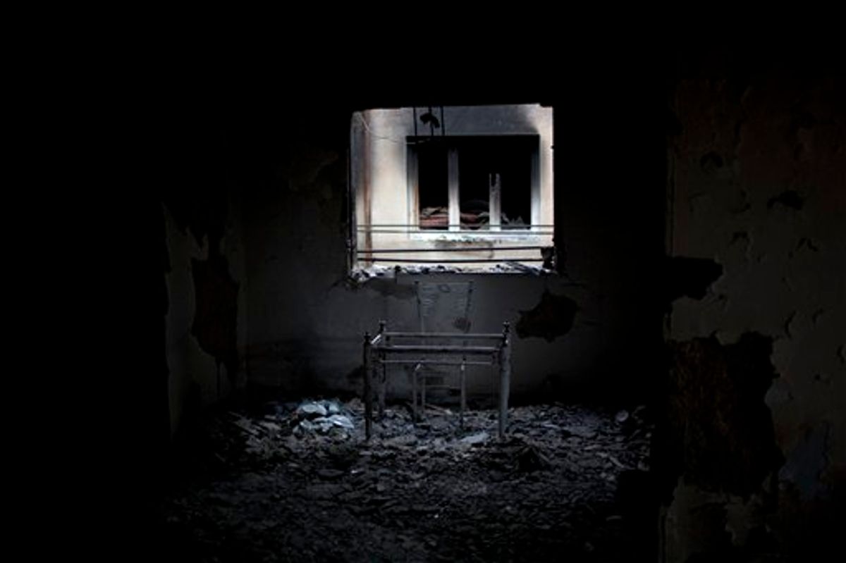 In this photo taken Tuesday, May 24 , 2011, a table and a chair are seen in an apartment used by snipers loyal to Libyan-leader Moammar Gadhafi and destroyed during fighting with rebels for the control of Tripoli Street, Misrata, Libya. Since the weeks-long siege of the city ended in mid-May, Misrata residents make pilgrimages to Tripoli Street, site of the fiercest fighting in the battle for Libya between the rebels and Moammar Gadhafi's forces. People gawk at the wreckage of bombed-out buildings with gaping holes and walls pocked by bullets, and shoot photos of charred hulks of tanks, rubble-strewn streets and a side walk museum featuring drumloads of bullet casings, uniforms of dead enemies, and unexploded munitions. (AP Photo/Rodrigo Abd) (AP)