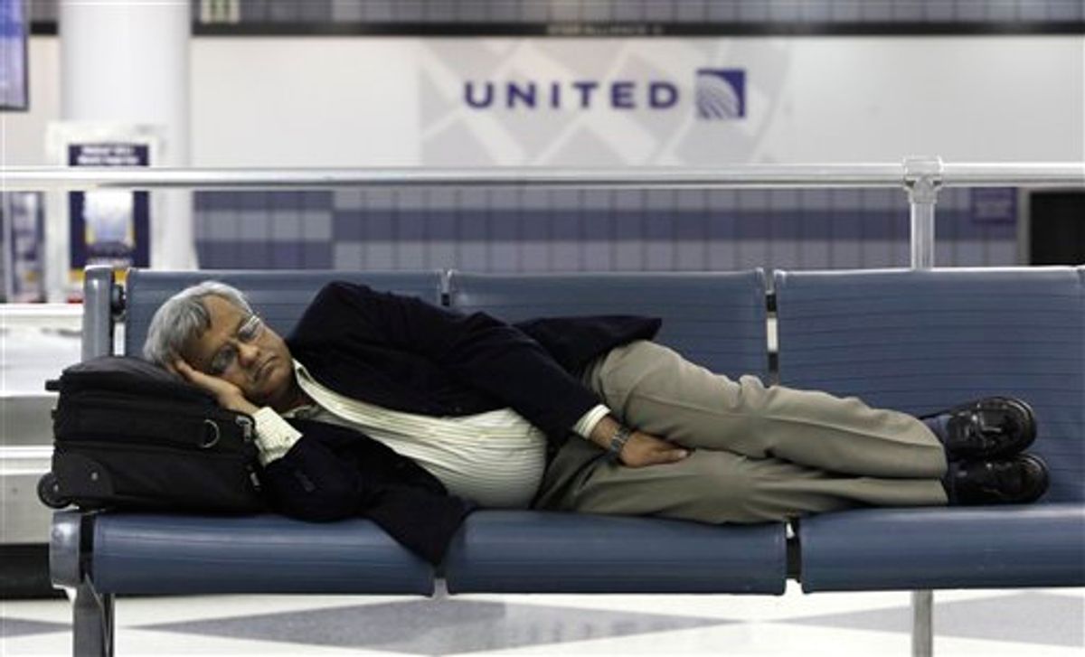 A stranded United Airlines passenger sleeps in Terminal 1 at O'Hare International Airport Saturday, June 18, 2011 in Chicago. Thousands of flyers were stranded Friday night in airports across the country when United Airlines computers crashed, interrupting departures and reservations and disrupting the airline's websites.  (AP Photo/Charles Rex Arbogast)      (AP)