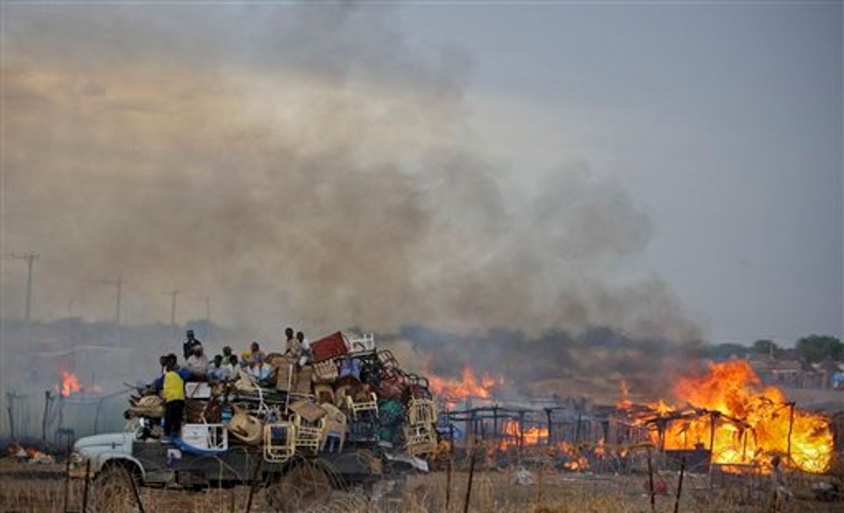 In this photo provided by the United Nations Mission in Sudan (UNMIS), a truck piled high with looted items drives past the burning huts of businesses and homesteads in the center of Abyei town, Sudan Saturday, May 28, 2011. Tens of thousands of Sudanese are fleeing from the contested north-south border region of Abyei, and the top U.S. official in the region warned Friday of a humanitarian crisis over the north's invasion. (AP Photo/UNMIS, Stuart Price) EDITORIAL USE ONLY, NO SALES  (AP)
