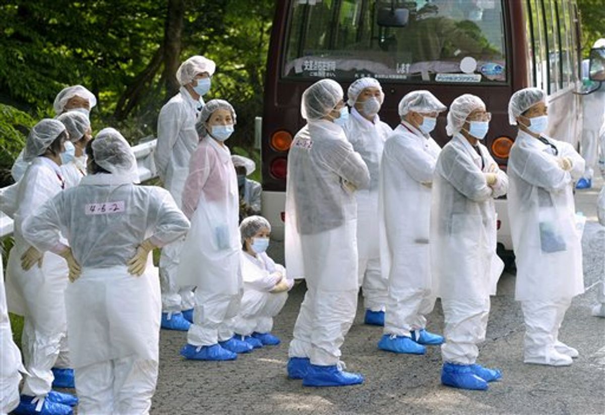 Evacuees in protective clothing wait for a substitute bus to come beside their disabled bus, after they returned for a a brief visit to their houses in the exclusion area, in Okuma, Fukushima prefecture, northeastern Japan, Saturday, June 4, 2011. The tsunami-crippled Fukushima Dai-ichi nuclear power plant is located in the town. (AP Photo/Kyodo News) JAPAN OUT, MANDATORY CREDIT, NO LICENSING IN CHINA, HONG KONG, JAPAN, SOUTH KOREA AND FRANCE (AP)