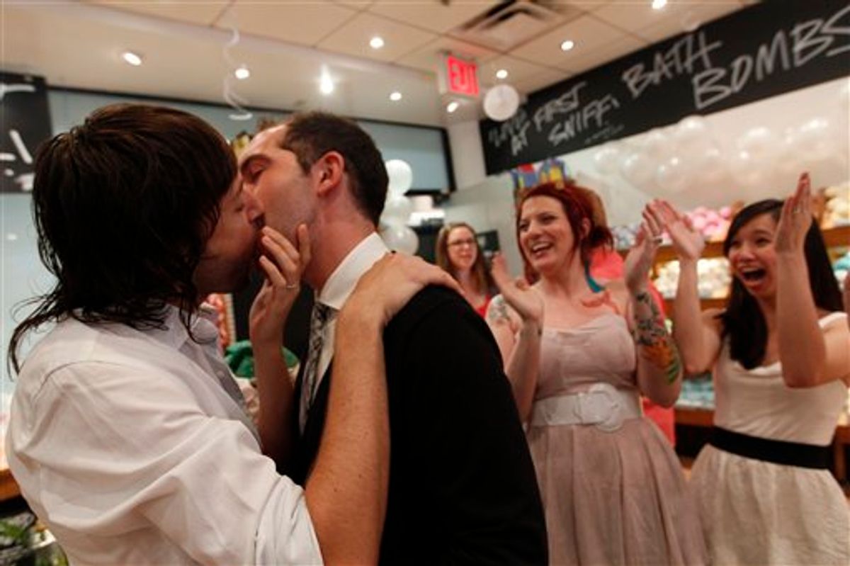 Lush Cosmetic employees Daniel Gervais, left, and David Casavant take part in a Kiss and Tell event in support of marriage equality as Amanda Halderman, second from right, and Perry Sun cheer them on, Saturday, June 18, 2011 in New York.  The State Senate left the Capitol on Friday without tackling same-sex marriage and other key issues, but Gov. Andrew M. Cuomo insisted lawmakers are on track to take action before the end of the legislative session slated for Monday. (AP Photo/Mary Altaffer) (AP)