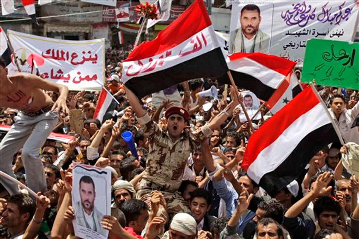 A Yemeni army soldier, center, lifted by anti-government protestors, reacts holding up his national flag with Arabic reads on it, " A thousand congratulations", as he and other demonstrators celebrate President Ali Abdullah Saleh's departure to Saudi Arabia, in Sanaa, Yemen, Sunday, June 5, 2011. Thousands of protesters are dancing and singing in the Yemeni capital Sanaa after the country's authoritarian leader flew to Saudi Arabia to receive medical treatment for wounds he suffered in a rocket attack on his compound. (AP Photo/Hani Mohammed) (AP)