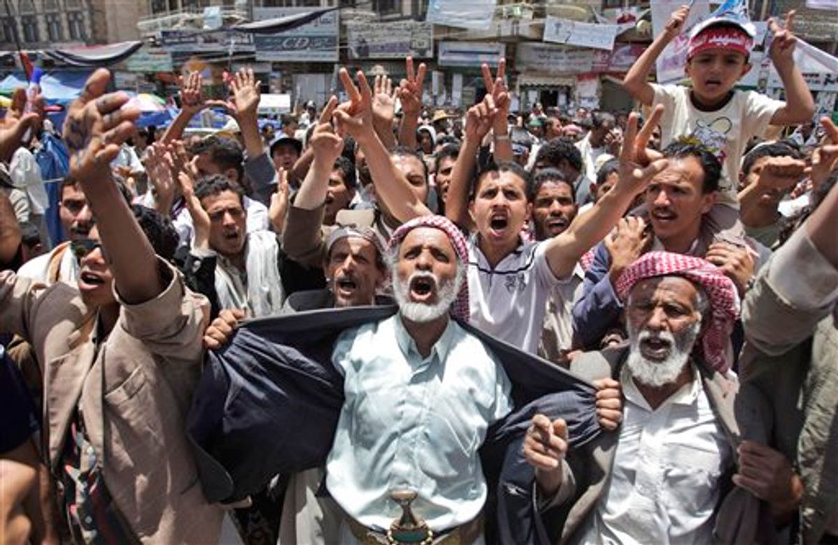 Anti-government protestors react during a demonstration demanding the resignation of Yemeni President Ali Abdullah Saleh, in Sanaa, Yemen, Monday, May 30, 2011. Yemeni warplanes carried out airstrikes Monday on a southern town seized by hundreds of Islamic militants over the weekend, witnesses said, as the political crisis surrounding the embattled president descended into more bloodshed. (AP Photo/Hani Mohammed) (AP)