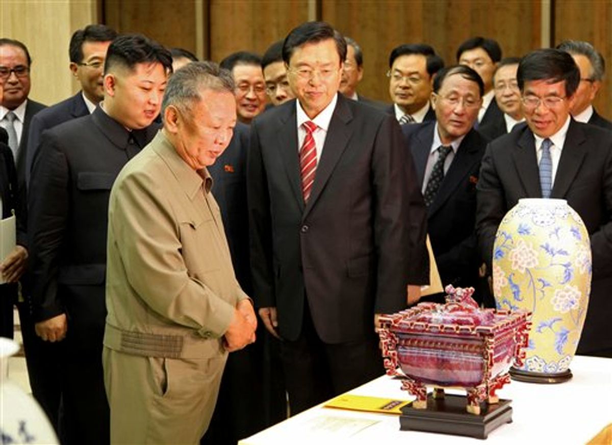 In this photo released by China's Xinhua News Agency, North Korean leader Kim Jong Il, front left, looks at gifts presented to him by Chinese Vice Premier Zhang Dejiang, center, head of a Chinese delegation to celebrate the 50th anniversary of the Treaty of Friendship, Cooperation and Mutual Assistance Between China and Democratic People's Republic of Korea, in Pyongyang, North Korea, on Tuesday, July 12, 2011. Kim Jong Il's son Kim Jong Un stands behind his father. (AP Photo/Xinhua, Zhang Li) NO SALES                      (AP)