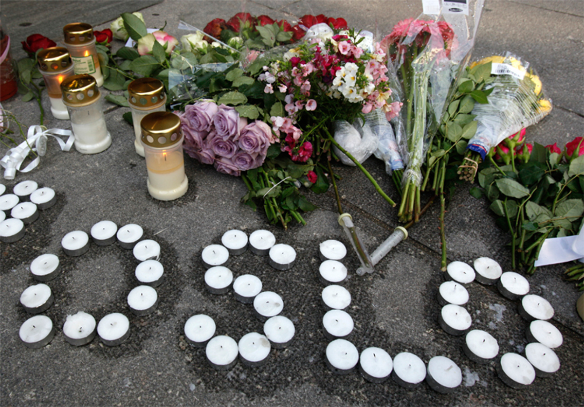 Candles and flowers are arranged on the ground near the blast site to mourn victims of the attacks