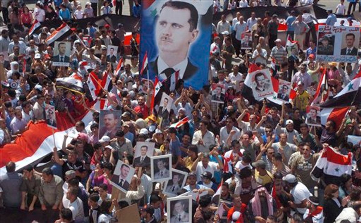 In this photo released by the Syrian official news agency SANA and according to them, Pro-Syrian President Bashar Assad demonstrators, display posters with his image,  during a gathering to show their support, at Ezraa village in Daraa province, Syria, on Wednesday July 6, 2011. Syrian security forces may have committed crimes against humanity during a deadly siege of a western town in May, Amnesty International said Wednesday, citing witness accounts of deaths in custody, torture and arbitrary detention. (AP Photo/SANA) EDITORIAL USE ONLY (AP)