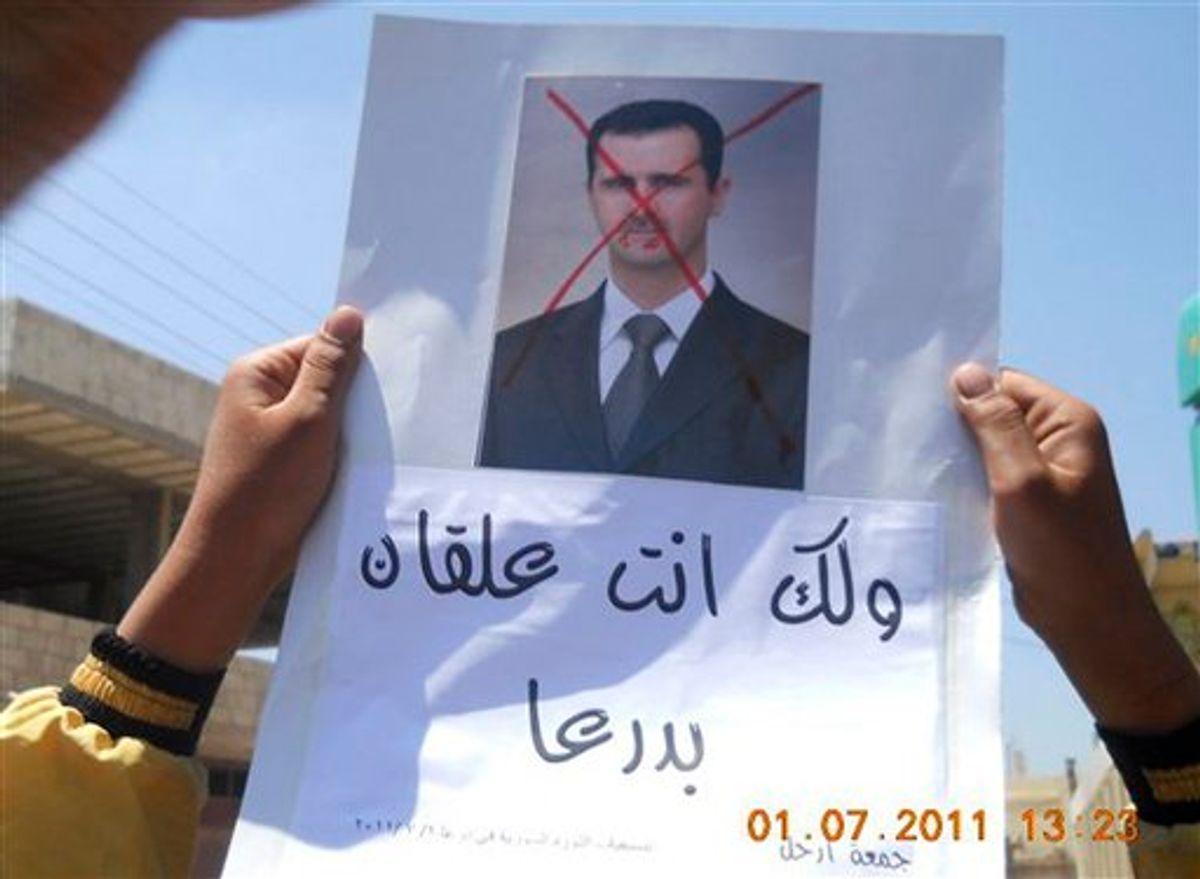 In this citizen journalism image made on a mobile phone and provided by Shaam News Network, anti-Syrian President Bashar Assad protester, holds up an Arabic placard read:"You are stuck in Daraa," during a demonstration against the Syrian regime, at Tafas village in Daraa province, southern Damascus, Syria, on Friday July 1, 2011. Hundreds of thousands of protesters flooded cities around Syria on Friday in one of the largest outpourings against the regime of President Bashar Assad since the uprisings began more than three months ago. At least six people were killed in various clashes, activists said. (AP Photo/Shaam News Network) EDITORIAL USE ONLY, NO SALES, THE ASSOCIATED PRESS IS UNABLE TO INDEPENDENTLY VERIFY THE AUTHENTICITY, CONTENT, LOCATION OR DATE OF THIS HANDOUT PHOTO (AP)