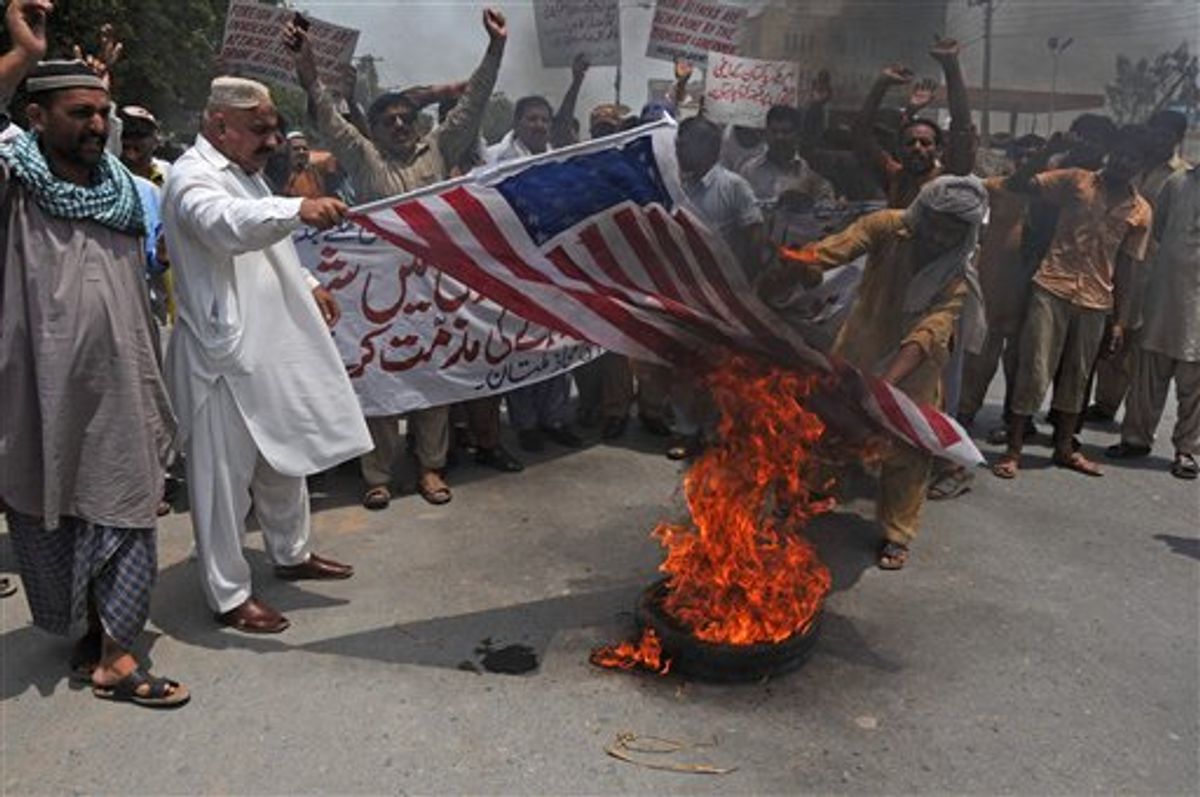 Pakistani protesters burn a representation of an American flag during a rally to condemn U. S. drone attacks targeting al-Qaida and Taliban militants' hideout in Pakistani tribal belt of Waziristan along the Afghanistan border, on Thursday, July 7, 2011 in Mutan, Pakistan. (AP Photo/Khalid Tanveer) (AP)