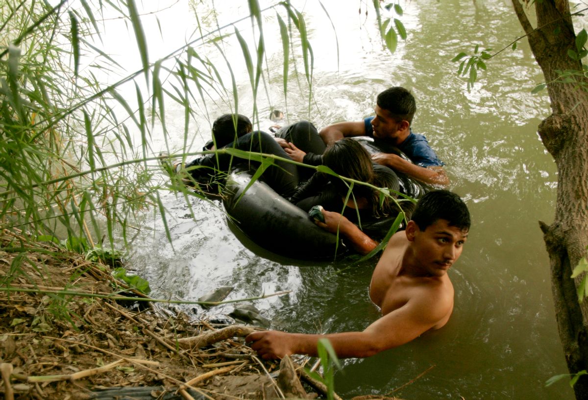 A group of illegal aliens wait on the U.S. side of the Rio Grande river, after floating across in a tire tube, in Laredo, Texas May 2, 2006. U.S. Border Patrol agents intercepted the group and they eventually went back to Mexico.   REUTERS/Rick Wilking (Reuters)