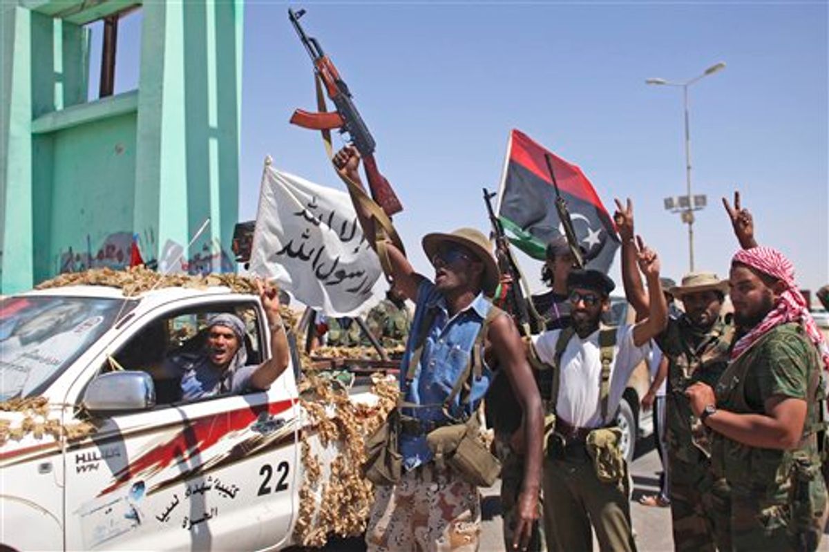 Rebel fighters celebrate at the gates of the town of Brega, Libya, Monday, Aug. 15, 2011.  Most of the town has been liberated from Moammar Gadhafi's forces, with fighting going on only at the oil terminal, according the rebel military spokesman, Ahmed Bani.  (AP Photo/Alexandre Meneghini) (AP)
