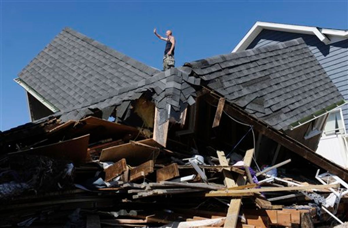 Tom Chase waves atop of his friend's beach home in the aftermath of Tropical Storm Irene, in East Haven, Conn., Monday, Aug. 29, 2011.  (AP Photo/Jessica Hill) (AP)
