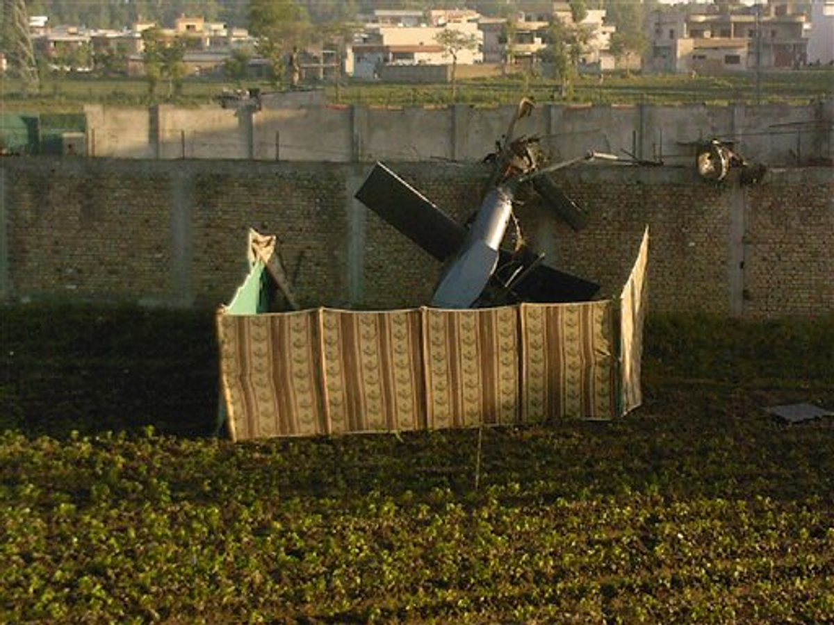 A photo taken by a local resident shows the wreckage of a helicopter next to the wall of the compound where Osama bin Laden was shot and killed in Abbottabad, Pakistan on Monday, May 2, 2011

