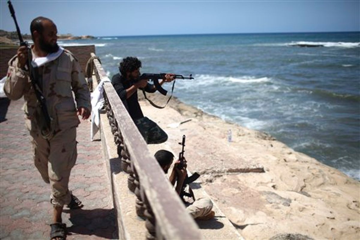 Rebel fighters shoot at what is allegedly Moammar Gadhafi's beach house in Tripoli, Monday, Aug. 29, 2011. (AP Photo/Alexandre Meneghini) (AP)