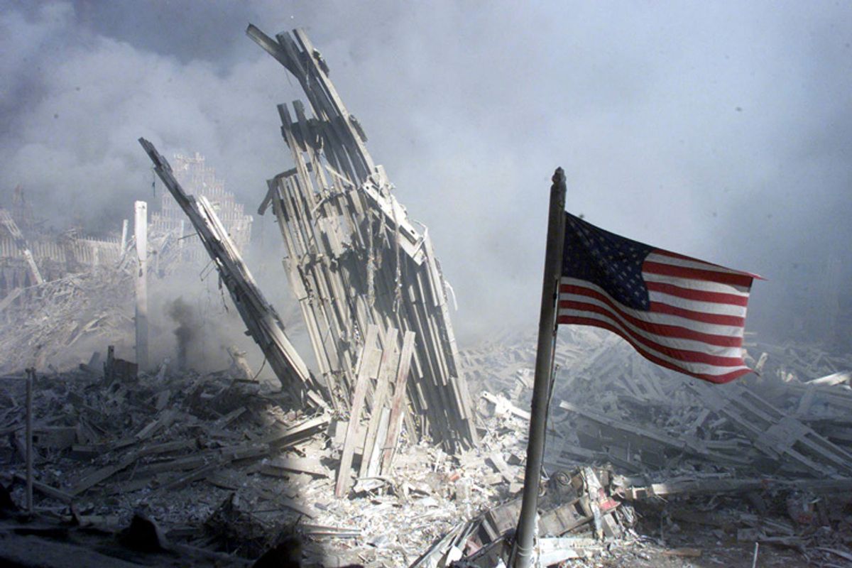 Am American flag flies near the base of the destroyed World Trade Center in New York, September 11, 2001. Planes crashed into each of the two towers, causing them to collapse.         (Â© Peter Morgan / Reuters)