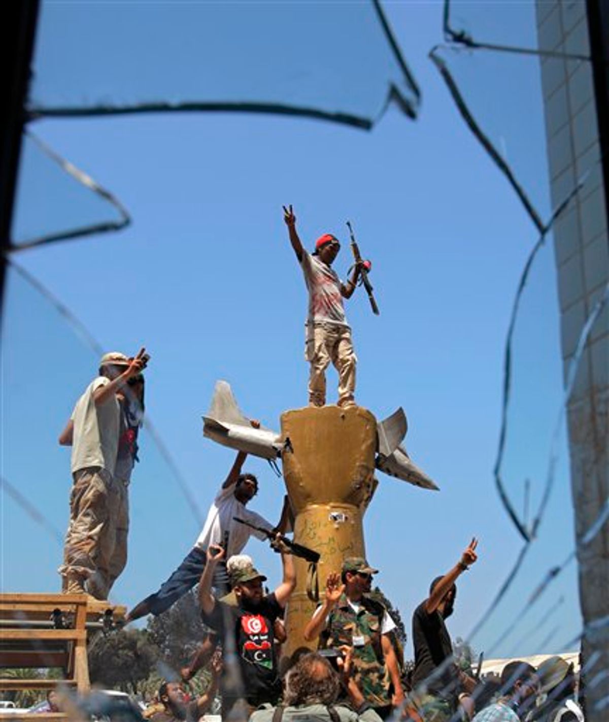 Rebel fighters celebrate as they stand on top of the monument inside the main Moammar Gadhafi compound in Bab Al-Aziziya in Tripoli, LIbya, Wednesday, Aug. 24, 2011. The rebels say they have now taken control of nearly all of Tripoli, but sporadic gunfire could still be heard Wednesday, and Gadhafi loyalists fired shells and assault rifles at fighters who had captured the Libyan leader's personal compound one day earlier. (AP Photo/Sergey Ponomarev) (AP)