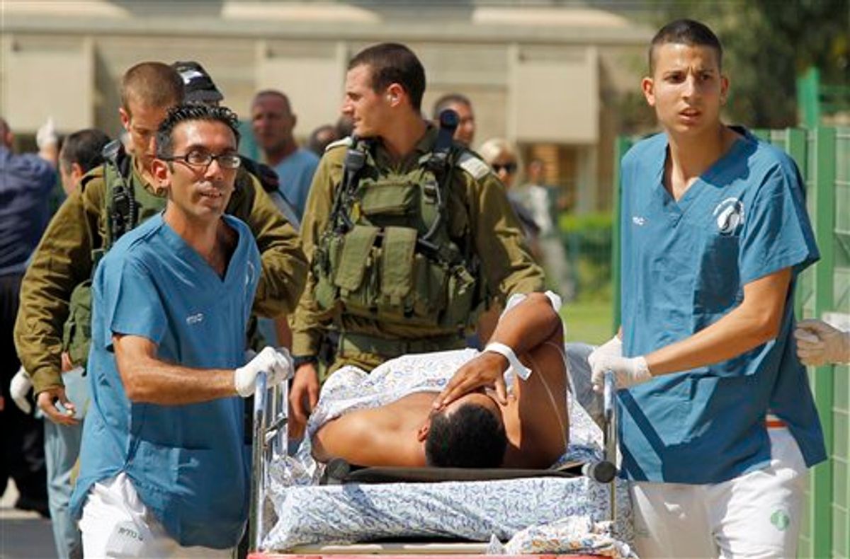 Israeli medics evacuate a person wounded in one of several attacks in the Arava desert, to the Soroka hospitan in Beersheba, southern Israel, Thursday, Aug. 18, 2011. Assailants armed with heavy weapons, guns and explosives crossed into southern Israel from the neighboring Egyptian Sinai peninsula on Thursday, killing six Israelis and wounding at least a dozen more in an audacious string of attacks that stoked concerns about Palestinian militants exploiting the recent instability in Egypt. (AP Photo/Ilan Assayag) ISRAEL OUT (AP)