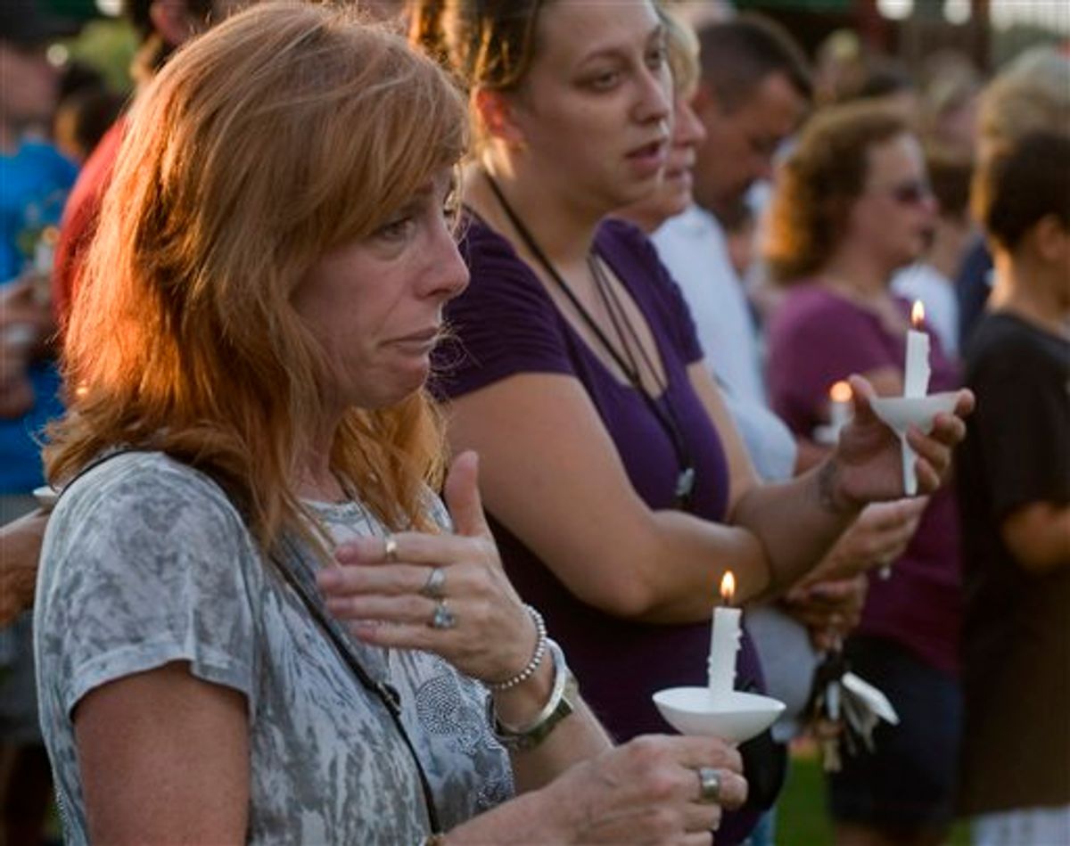 Bambi Lynn of Fairlawn, Ohio, wipes away tears during a prayer vigil at Copley Community Park in Copley Township, Ohio, Sunday, Aug. 7, 2011. A man gunned down two people outside an Ohio home and two more in a car Sunday morning, then shot his girlfriend in a rampage that left eight dead including the gunman, who was shot by police, authorities and witnesses said. Lynn is fearful that one of the victims is a co-worker. (AP Photo/Phil Long) (AP)