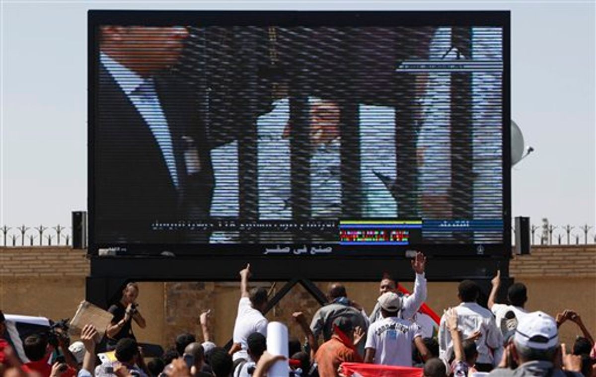 Egypt's ousted President Hosni Mubarak  is seen on a TV screen as he enters the courtroom on a hospital bed, outside the  Police Military Academy complex in Cairo, Egypt Wednesday, Aug. 3, 2011. Egypt's ousted President Hosni Mubarak was wheeled into a Cairo courtroom on a gurney Wednesday at the start of his historic trial on charges of corruption and ordering the killing of protesters during the uprising that ousted him. The scene, shown live on Egypt's state TV, was Egyptians' first look at their former president since Feb. 10, the day before his fall when he gave a defiant speech refusing to resign. (AP Photo/Nasser Nasser) (AP)