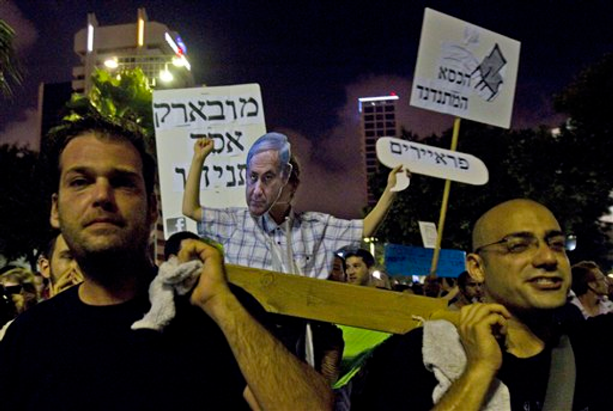 Israelis march with a stretcher with a person wearing a mask of Israel's Prime Minister Benjamin Netanyahu during a protest in central Tel Aviv, Saturday, July 30, 2011