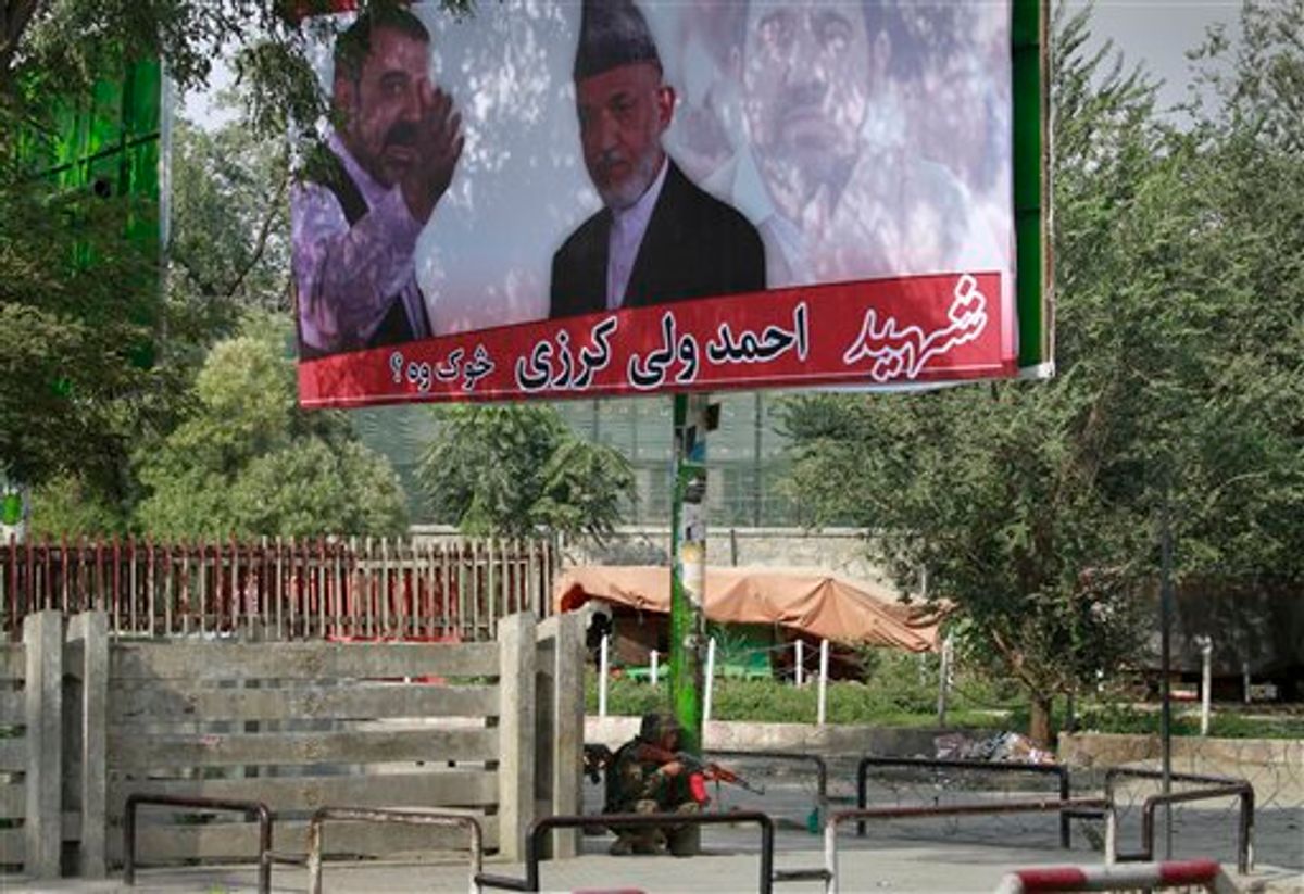 An Afghan soldier takes position under a huge poster of Afghan President Hamid Karzai with his late brother Ahmad Wali Karzai, during a gun battle with militants in Kabul, Afghanistan on Tuesday, Sept. 13, 2011. Taliban insurgents fired rocket-propelled grenades and assault rifles at the U.S. Embassy, NATO headquarters and other buildings in the heart of the Afghan capital Tuesday in a brazen attack two days after the United States marked the 10th anniversary of the Sept. 11 terror attacks. (AP Photo/Musadeq Sadeq) (AP)